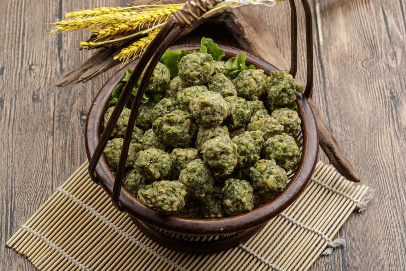 棕色竹篮装的飘香油炸野菜丸子图片