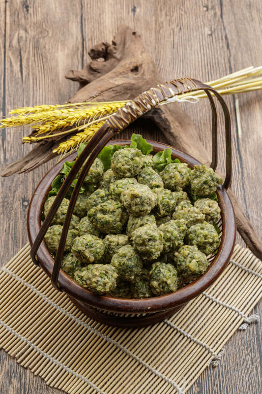 棕色竹篮装的飘香油炸野菜丸子图片