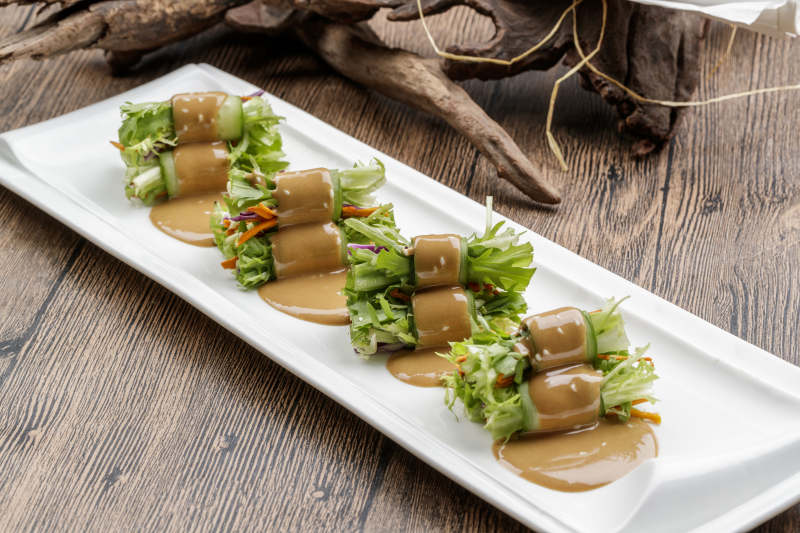 白色瓷盘装的芝麻酱乳瓜卷苦菊图片