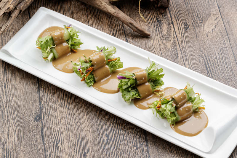 白色瓷盘装的芝麻酱乳瓜卷苦菊图片