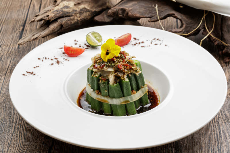 白色瓷盘装的捞汁秋葵图片