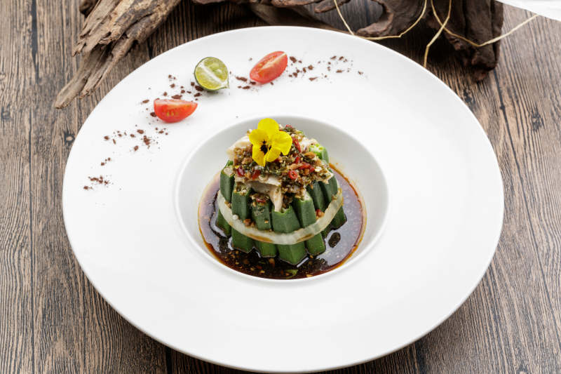 白色瓷盘装的捞汁秋葵图片