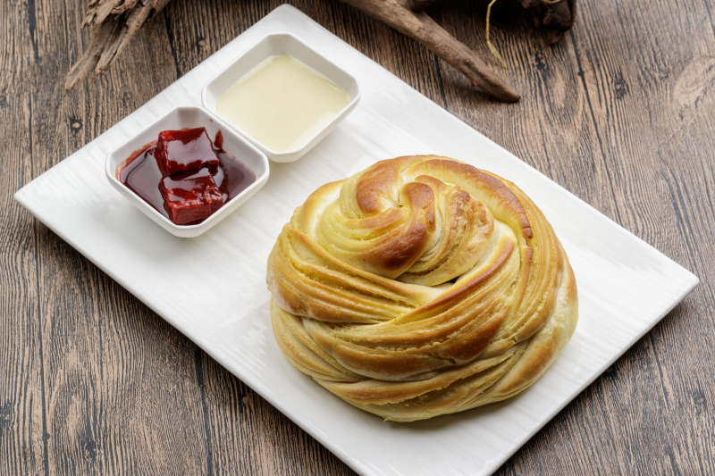 白色瓷盘装的炼乳腐乳烤大花卷图片