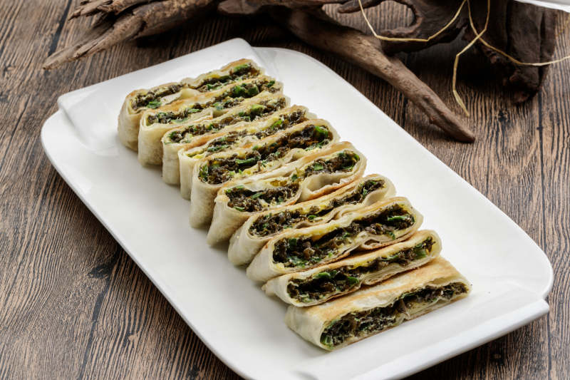 白色瓷盘装的鸡蛋地皮菜陷烙饼图片