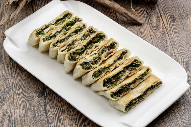 白色瓷盘装的鸡蛋地皮菜陷烙饼图片