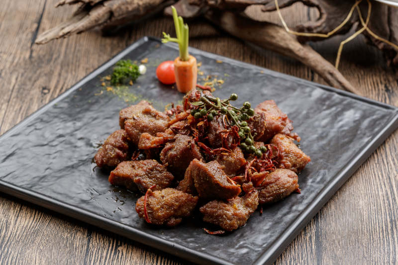 黑色石盘装的藤椒川香牛仔粒图片