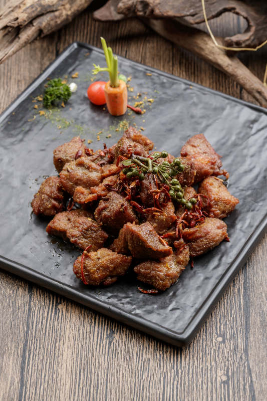 黑色石盘装的藤椒川香牛仔粒图片