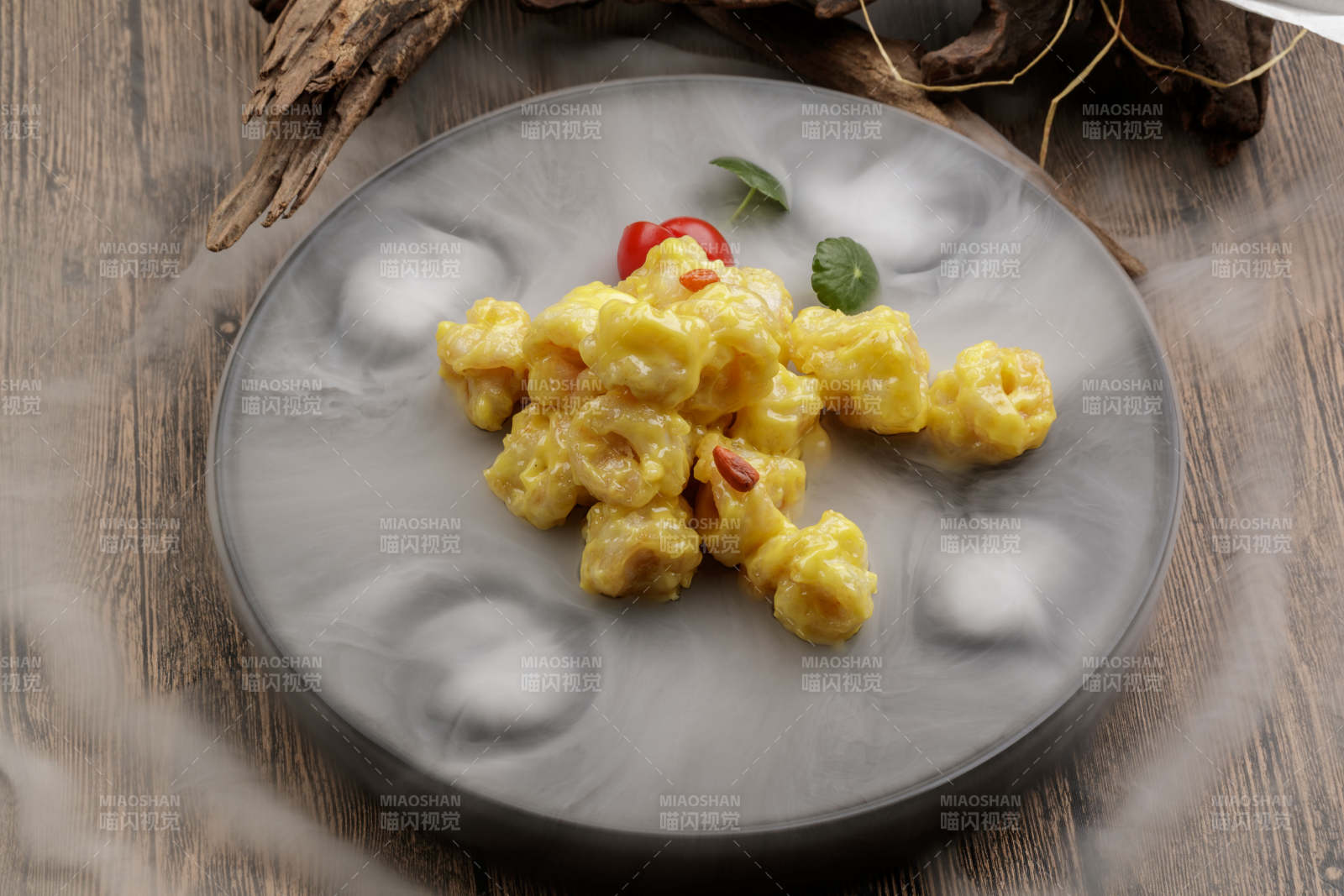 干冰缭绕的餐具摆放的芥香焗虾球图片