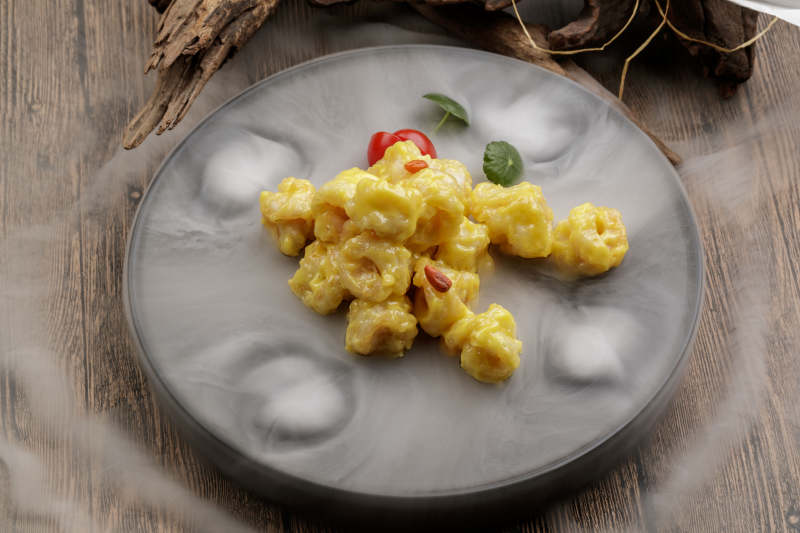 干冰缭绕的餐具摆放的芥香焗虾球图片