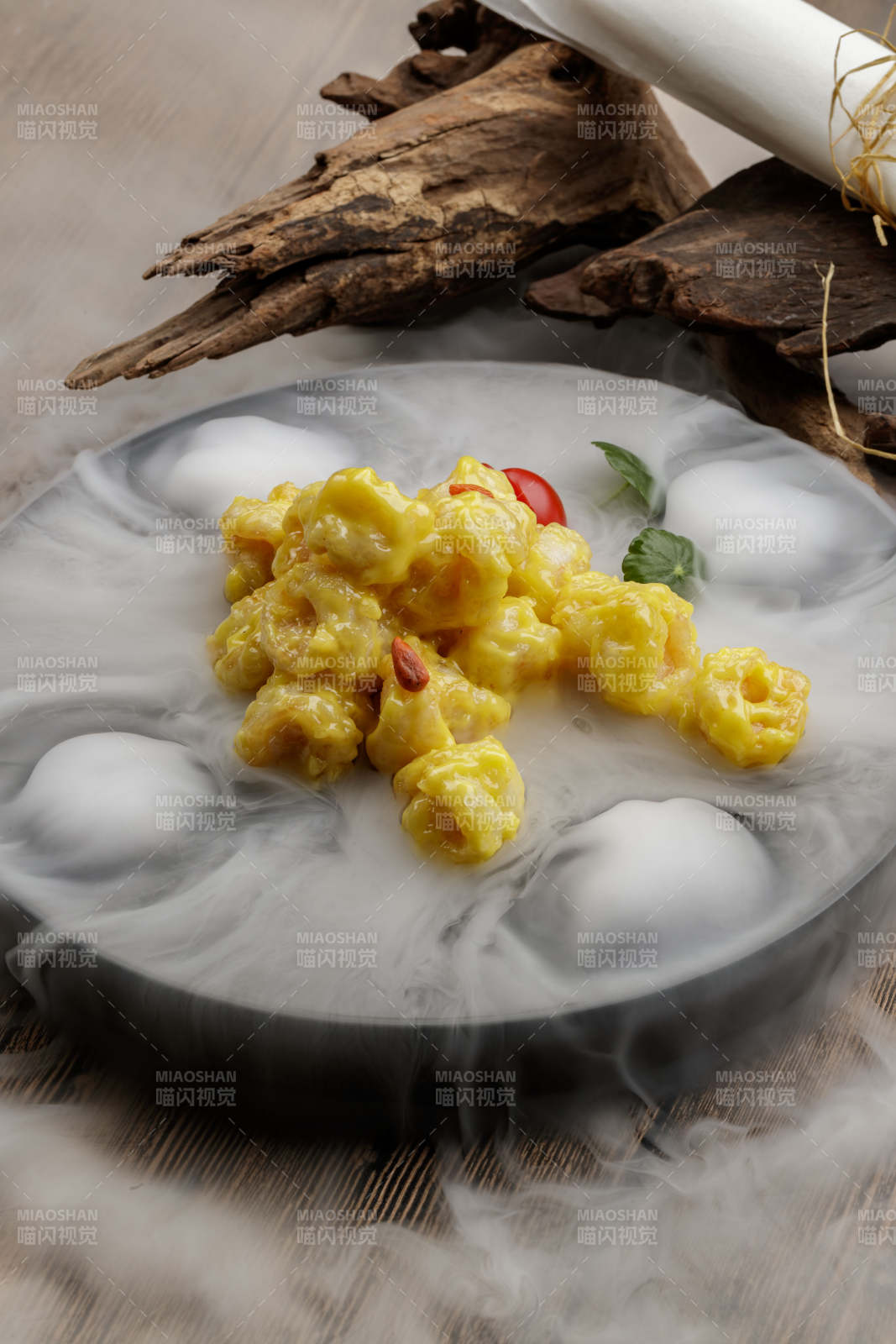 干冰缭绕的餐具摆放的芥香焗虾球图片