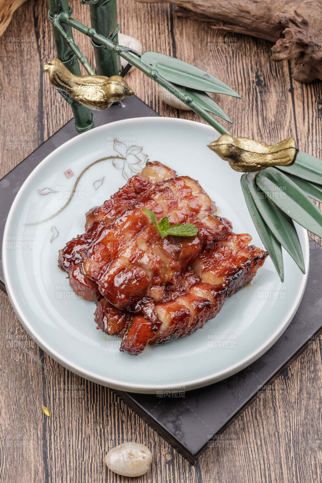 米花色瓷盘装的蜜汁叉烧肉摆放在樟木砧板上图片