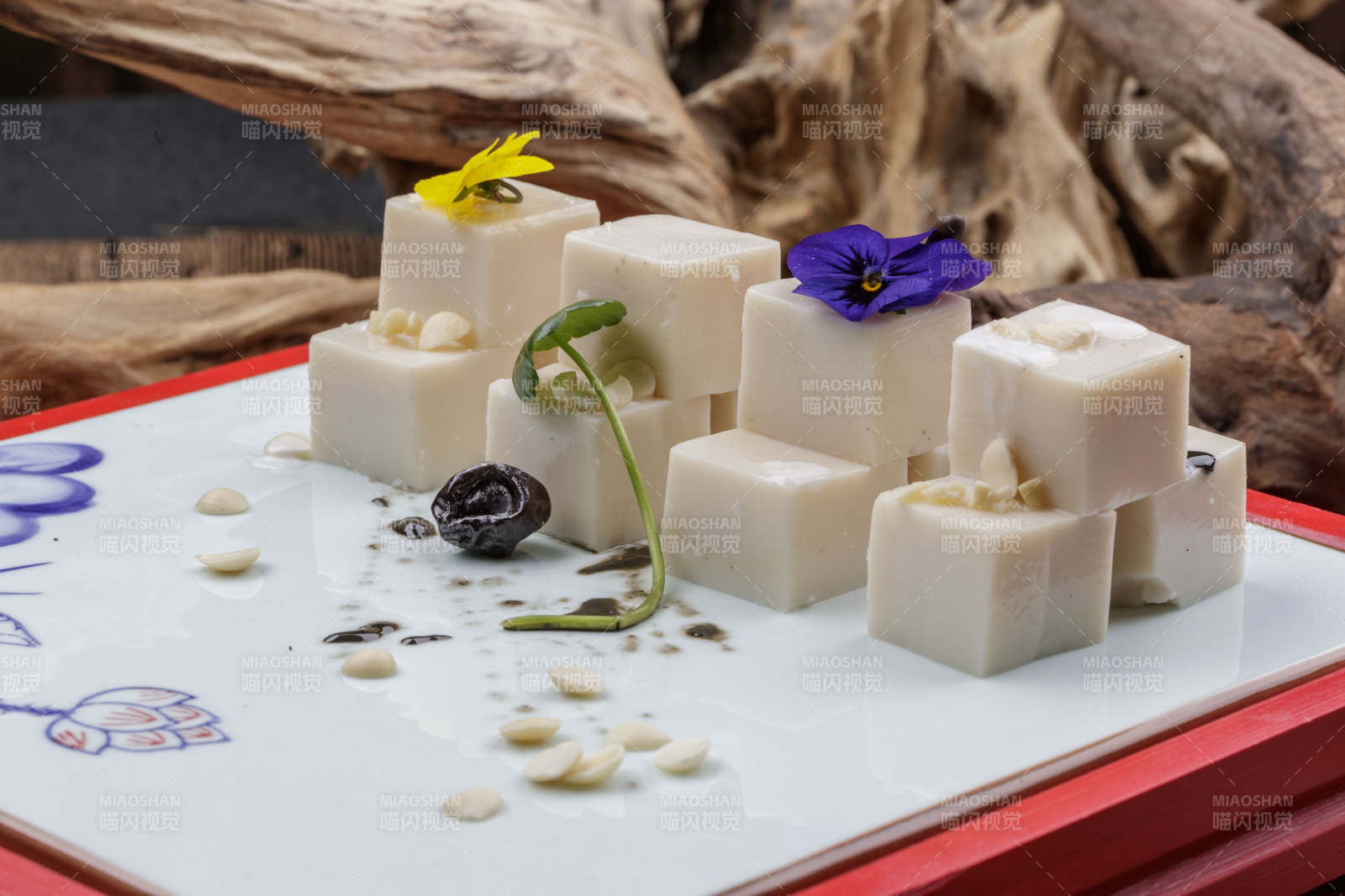 圆形黑色石盘装的奶香杏仁糕摆放在寿司帘上图片