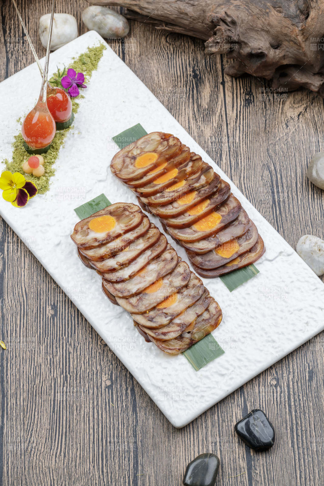 白色瓷盘装的猪耳鱿鱼蛋黄卷图片