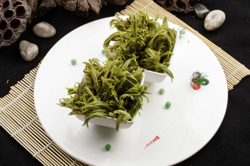 白色瓷盘装的盐水凉拌香椿苗图片