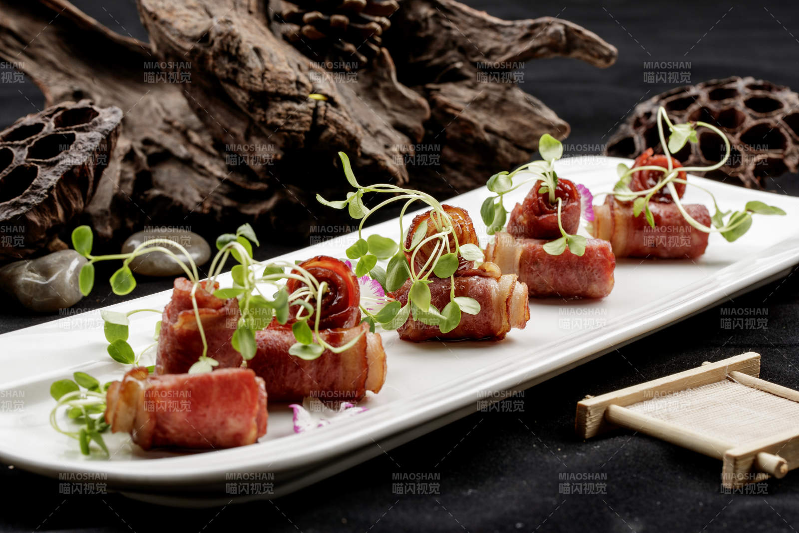 白色瓷盘装的香椿苗培根卷图片