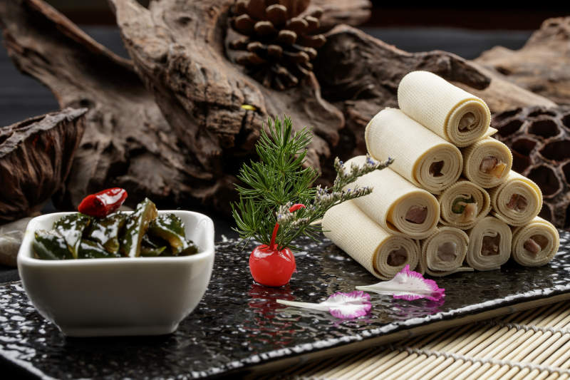 黑石盘餐具装的怀安千张豆腐皮卷熏肉配酱黄瓜图片