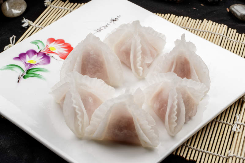 白色瓷盘装的蒸猪肉鲜蒸虾饺图片