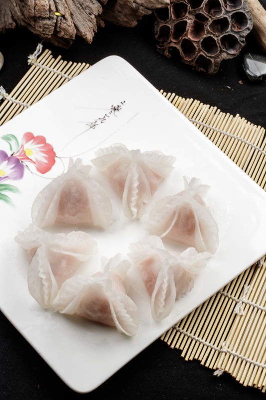 白色瓷盘装的蒸猪肉鲜蒸虾饺图片