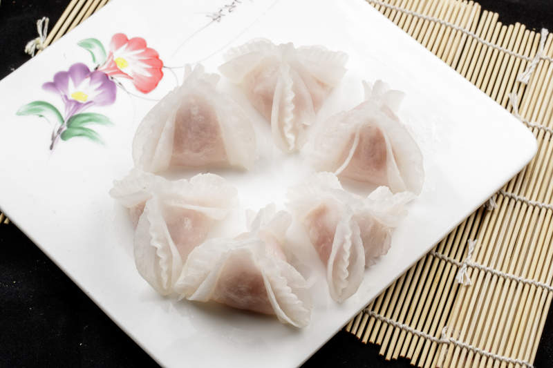 白色瓷盘装的蒸猪肉鲜蒸虾饺图片