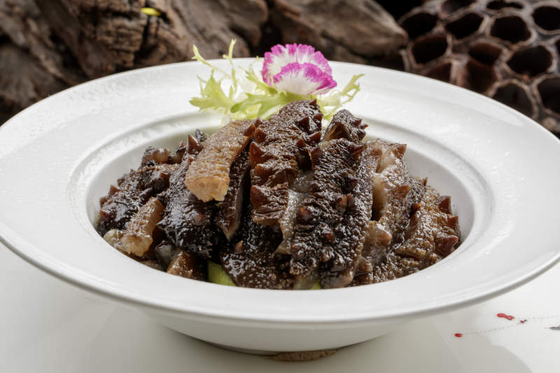 白色餐具装的清炖梅花参段图片