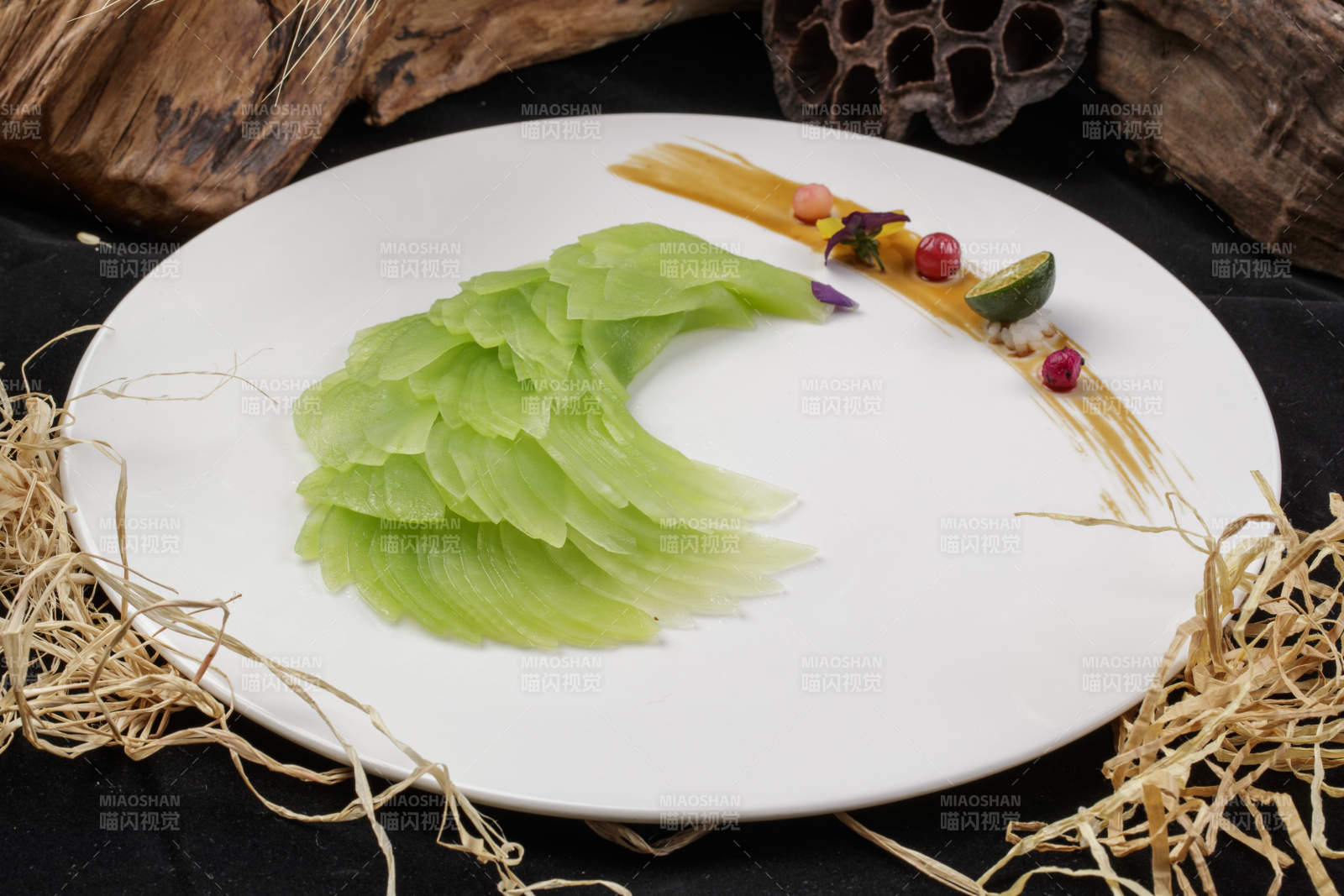 白色圆瓷盘装的凤尾青笋摆放在黑色背景上图片