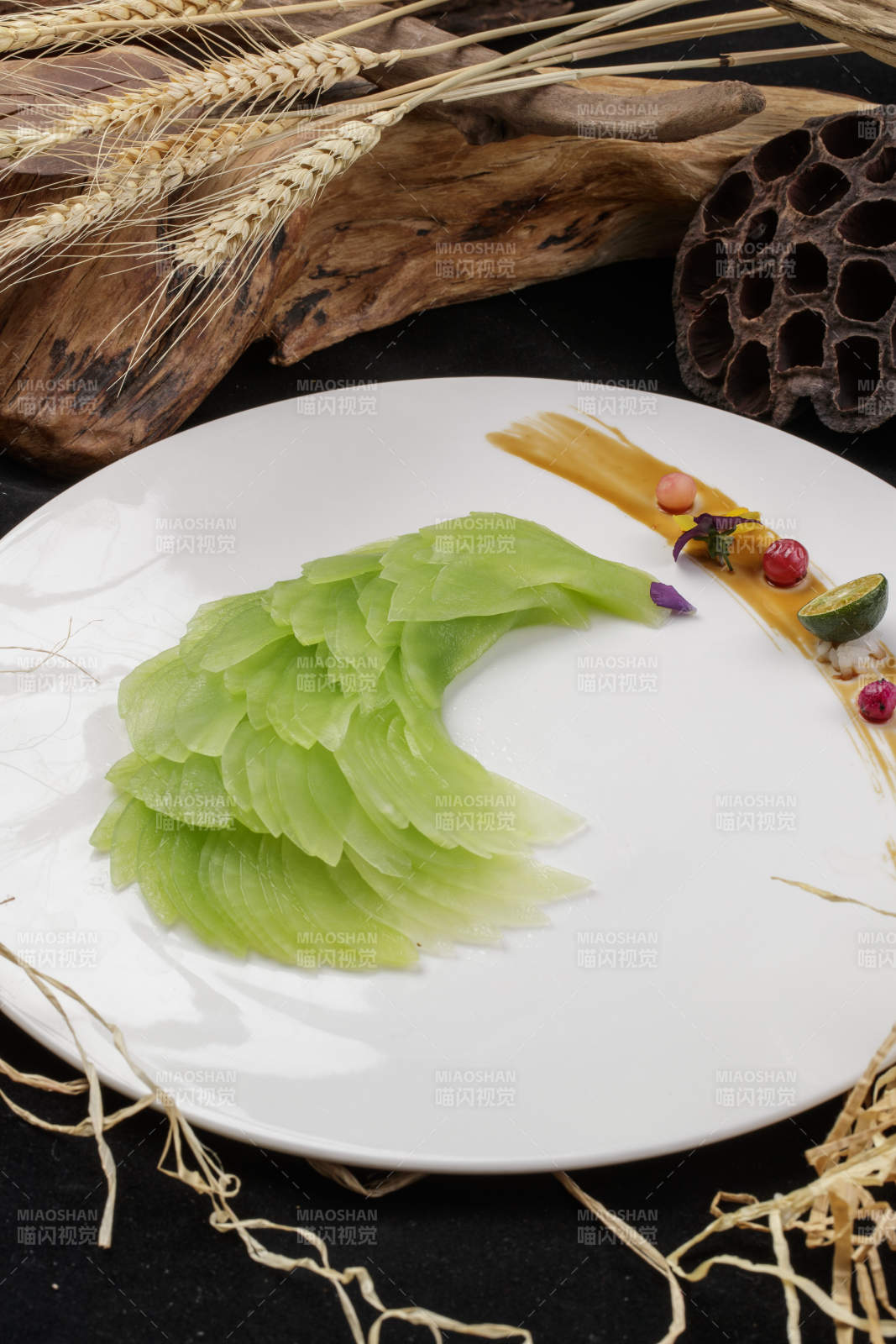 白色圆瓷盘装的凤尾青笋摆放在黑色背景上图片