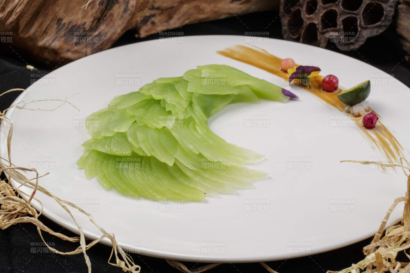 白色圆瓷盘装的凤尾青笋摆放在黑色背景上图片