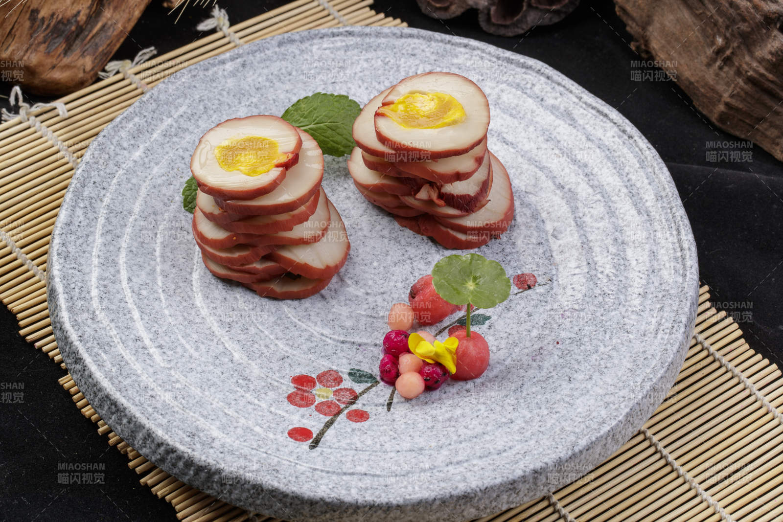 鱿鱼卷海鸭蛋摆放在寿司帘上图片
