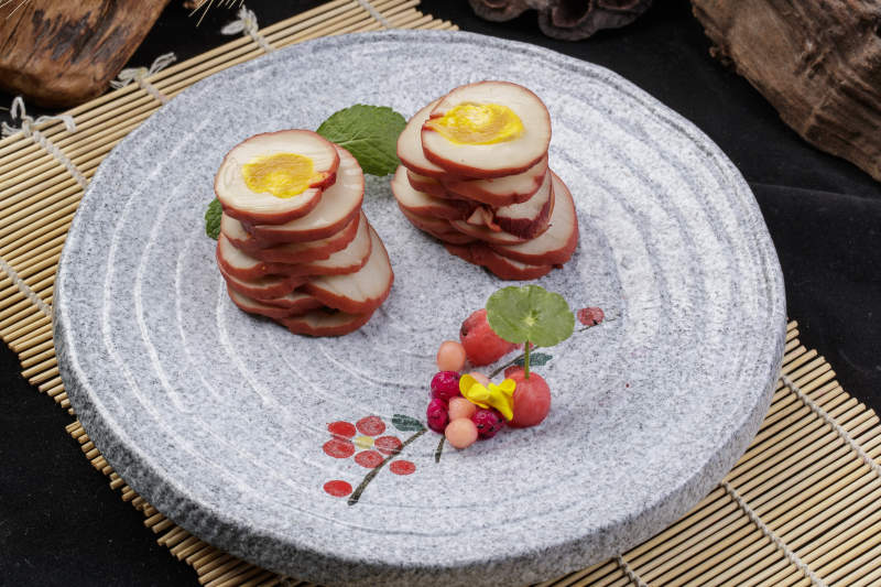 鱿鱼卷海鸭蛋摆放在寿司帘上图片