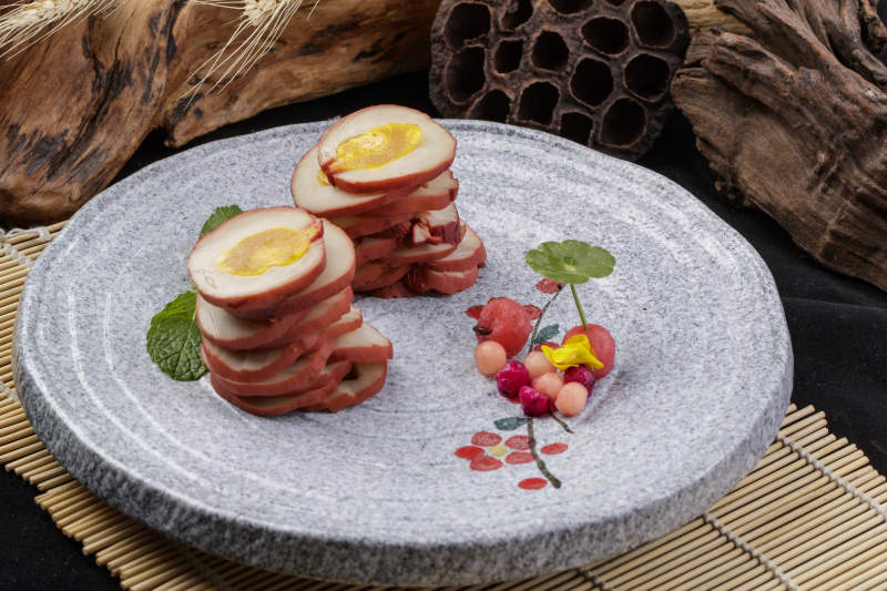 鱿鱼卷海鸭蛋摆放在寿司帘上图片