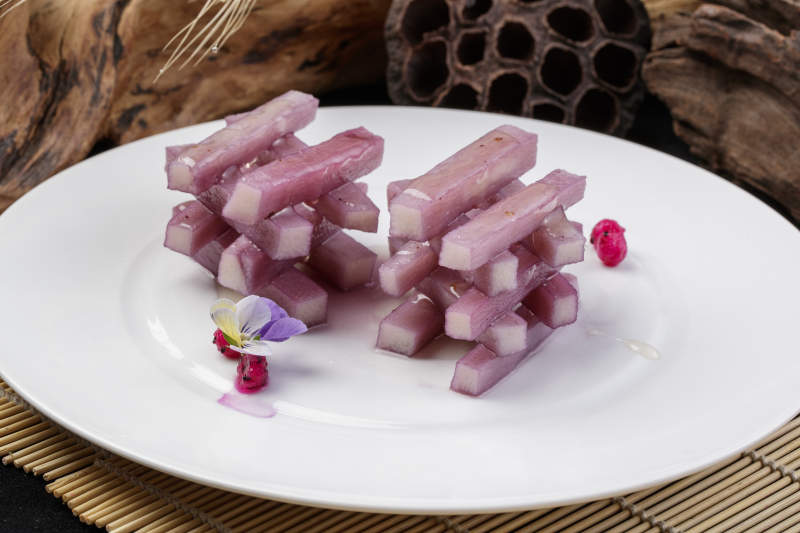 圆形瓷盘装的蓝莓长山药摆放在寿司帘上图片