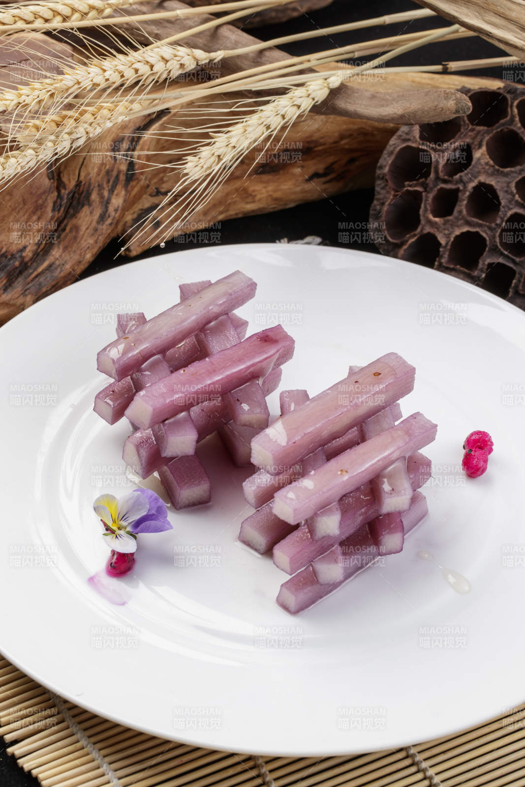 圆形瓷盘装的蓝莓长山药摆放在寿司帘上图片