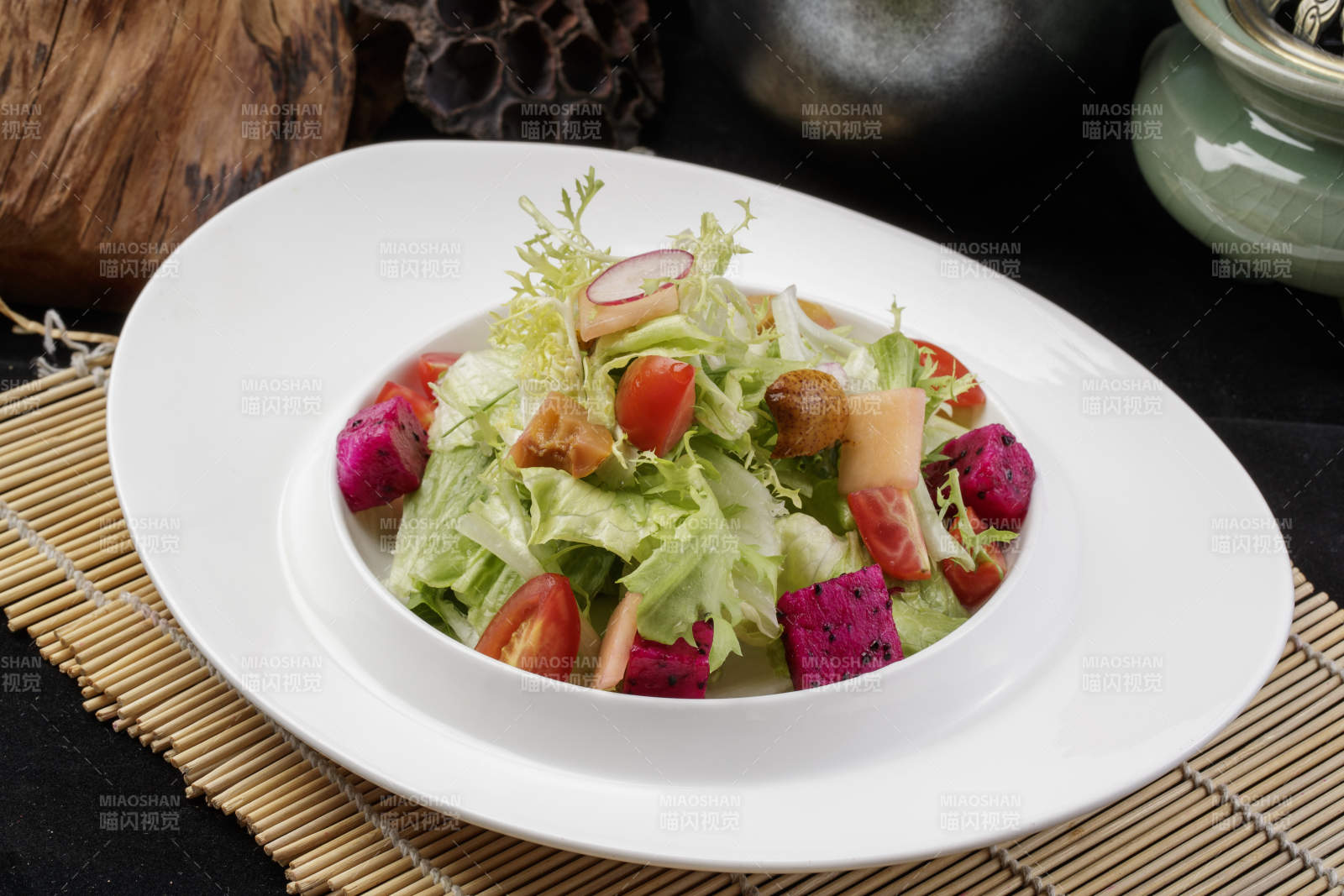 托圆瓷盘装的果蔬拌菜摆放在寿司帘上图片