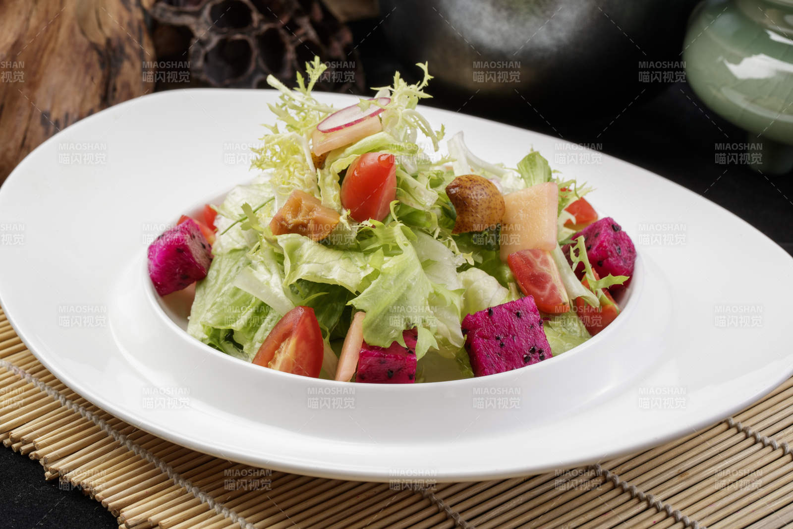 托圆瓷盘装的果蔬拌菜摆放在寿司帘上图片