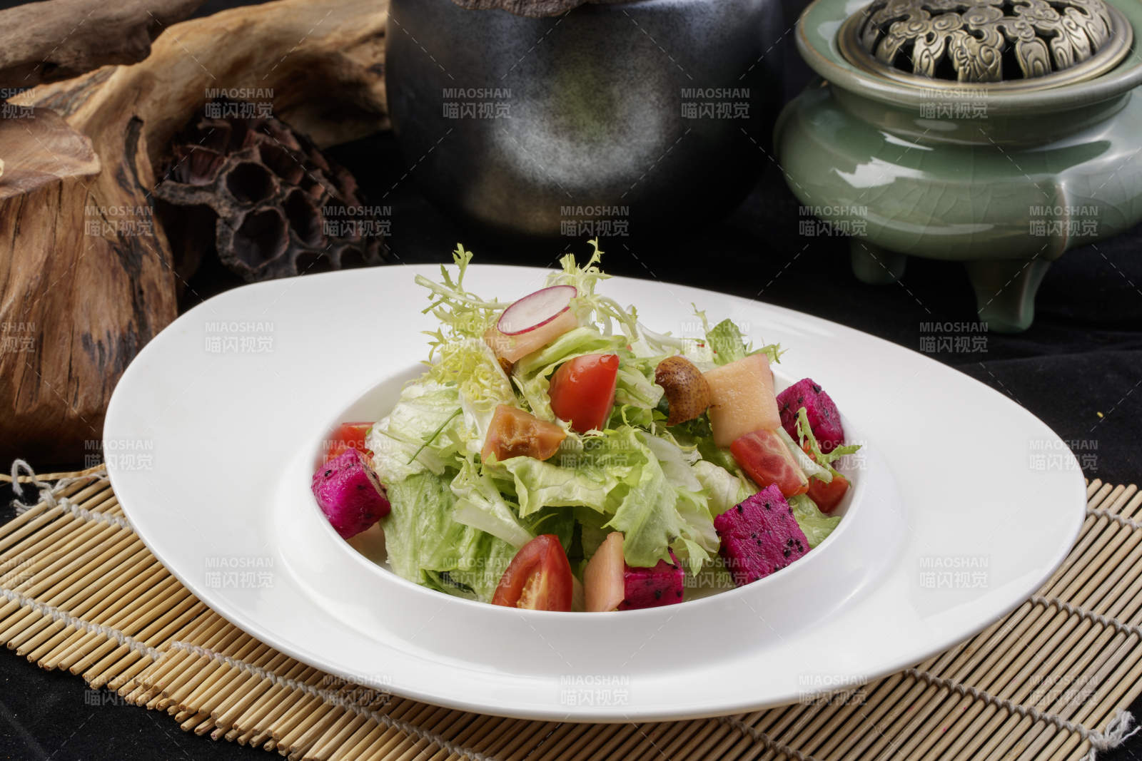 托圆瓷盘装的果蔬拌菜摆放在寿司帘上图片