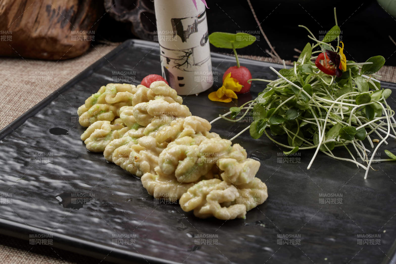 黑色瓷盘装的飘香桃仁黑豆苗图片