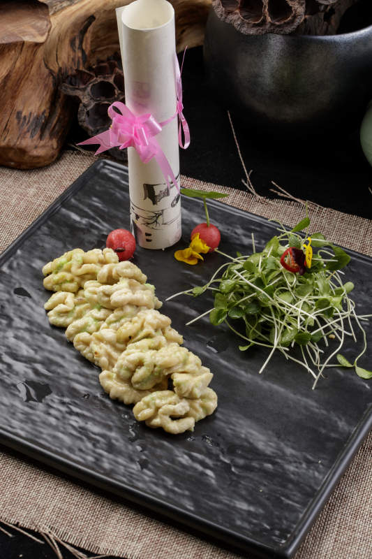 黑色瓷盘装的飘香桃仁黑豆苗图片