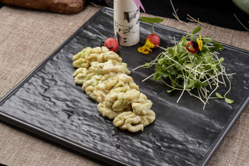 黑色瓷盘装的飘香桃仁黑豆苗图片