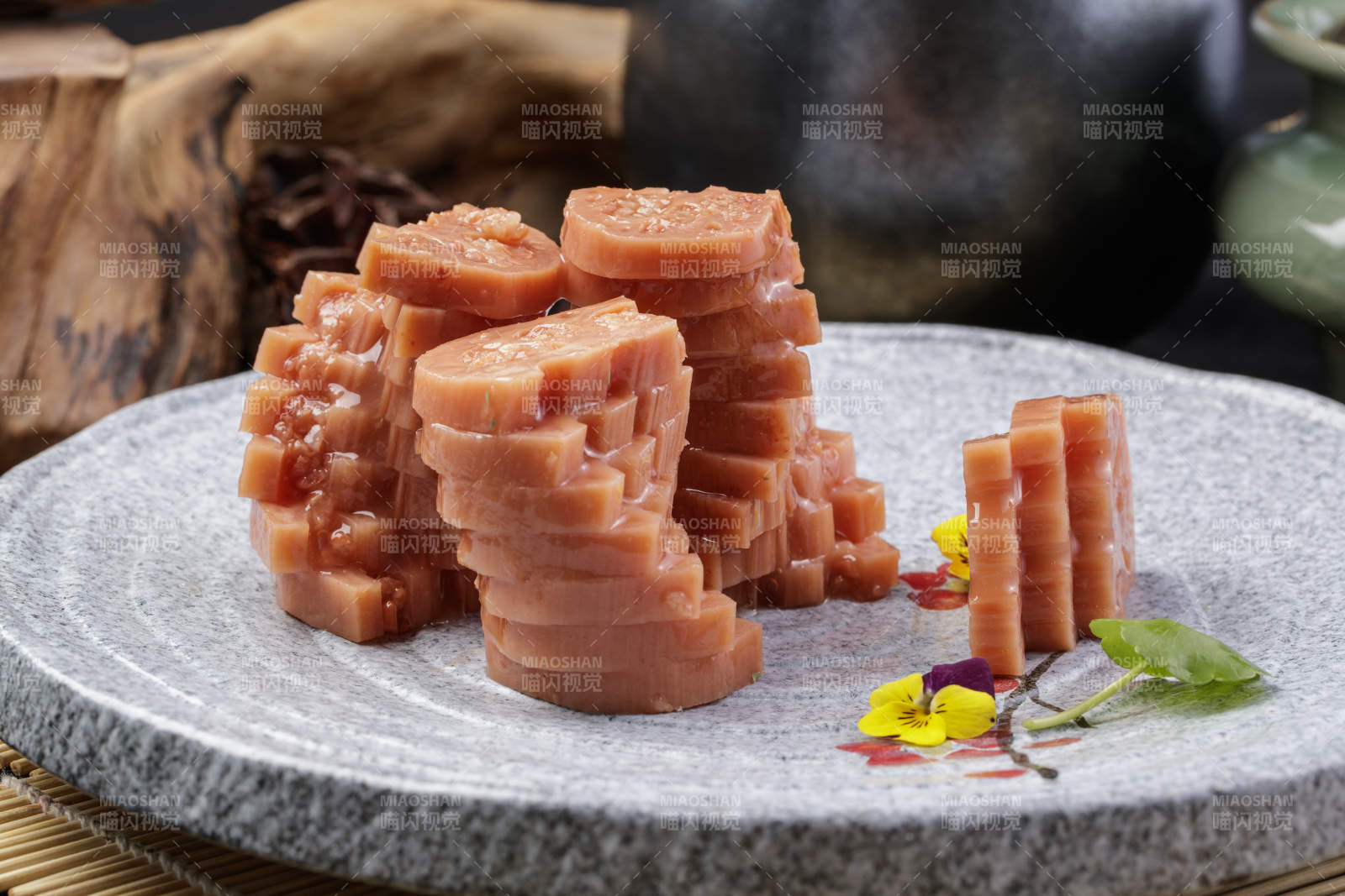 灰色螺旋瓷盘装的蜂蜜黄米藕摆放在寿司帘上图片