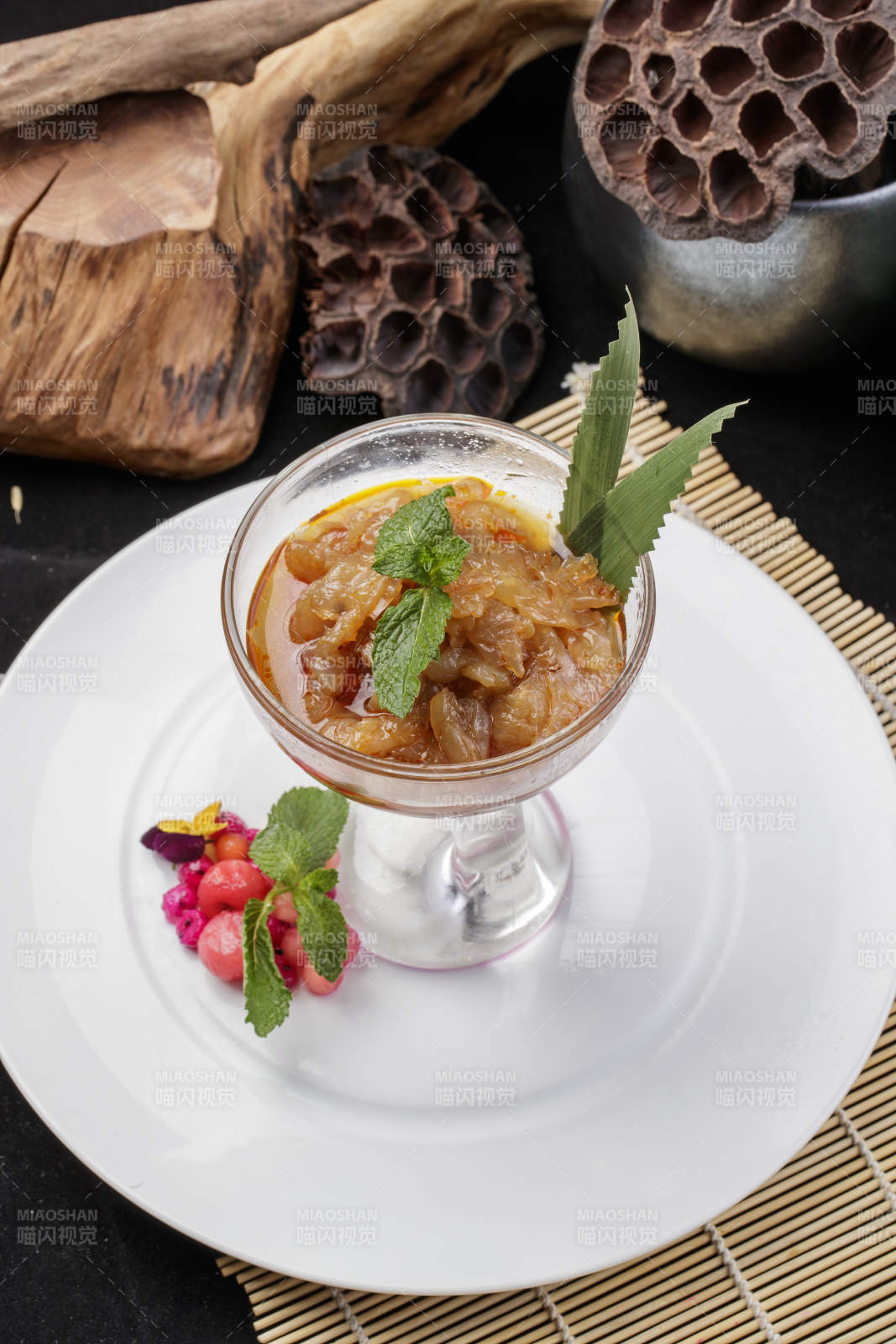 玻璃盏装的老醋蛰头摆放在白色瓷盘上图片