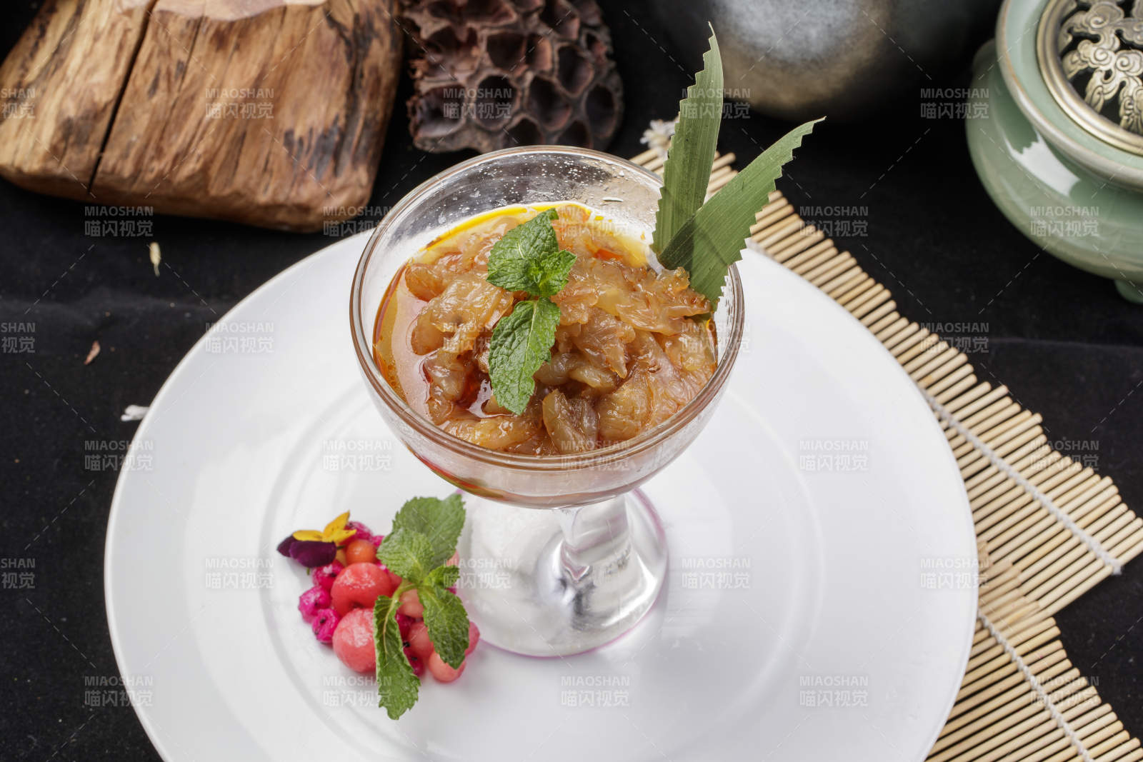 玻璃盏装的老醋蛰头摆放在白色瓷盘上图片