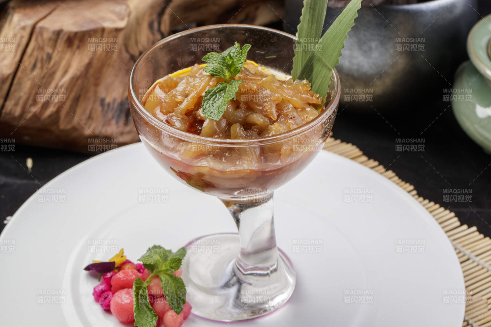 玻璃盏装的老醋蛰头摆放在白色瓷盘上图片