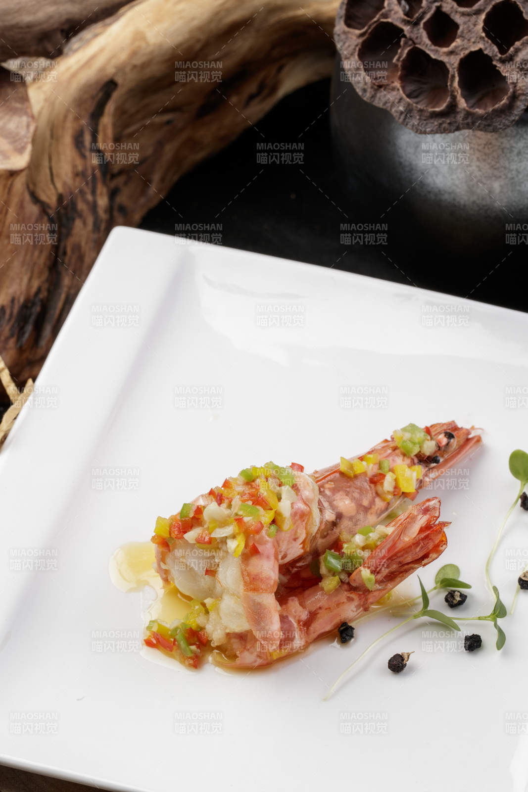 方形瓷盘装的开背大虾摆放在樟木砧板上图片