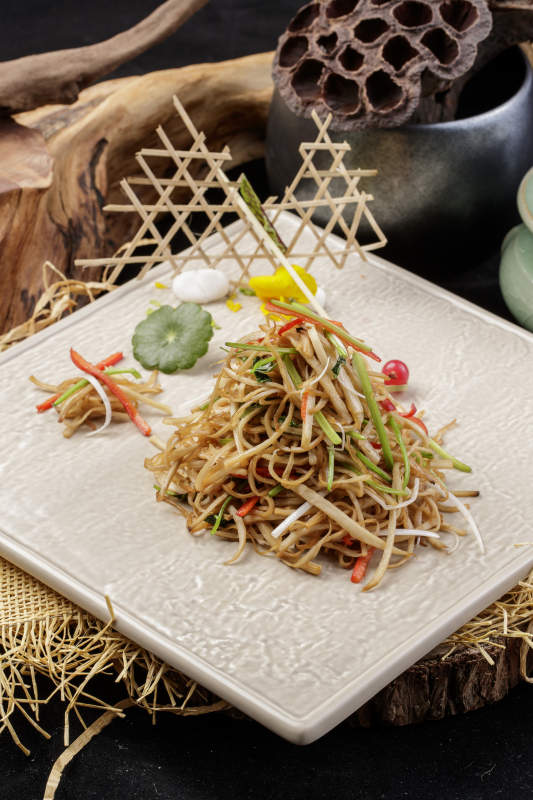 米色放瓷盘装的炝炒素三丝摆放在草垫子上图片