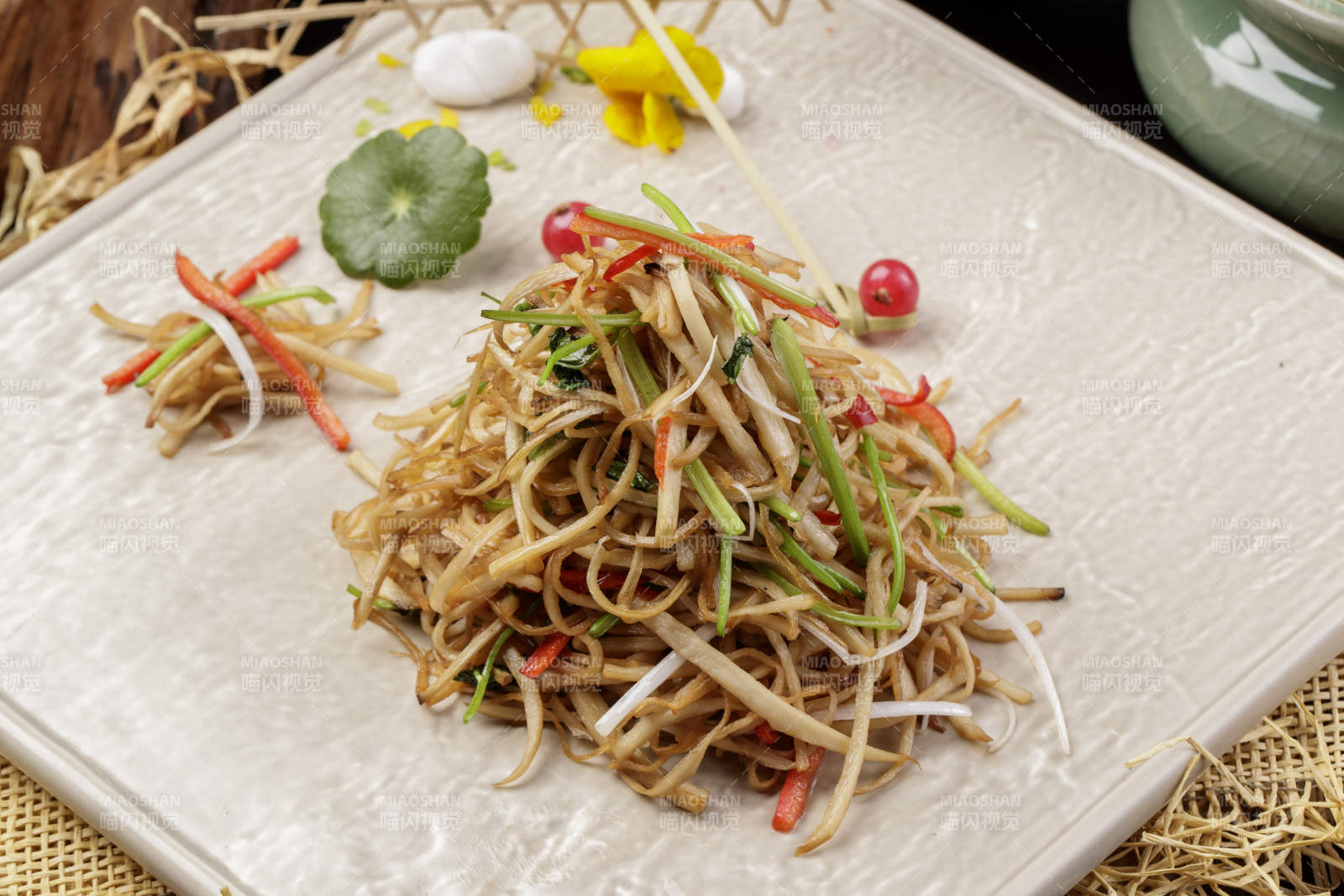 米色放瓷盘装的炝炒素三丝摆放在草垫子上图片