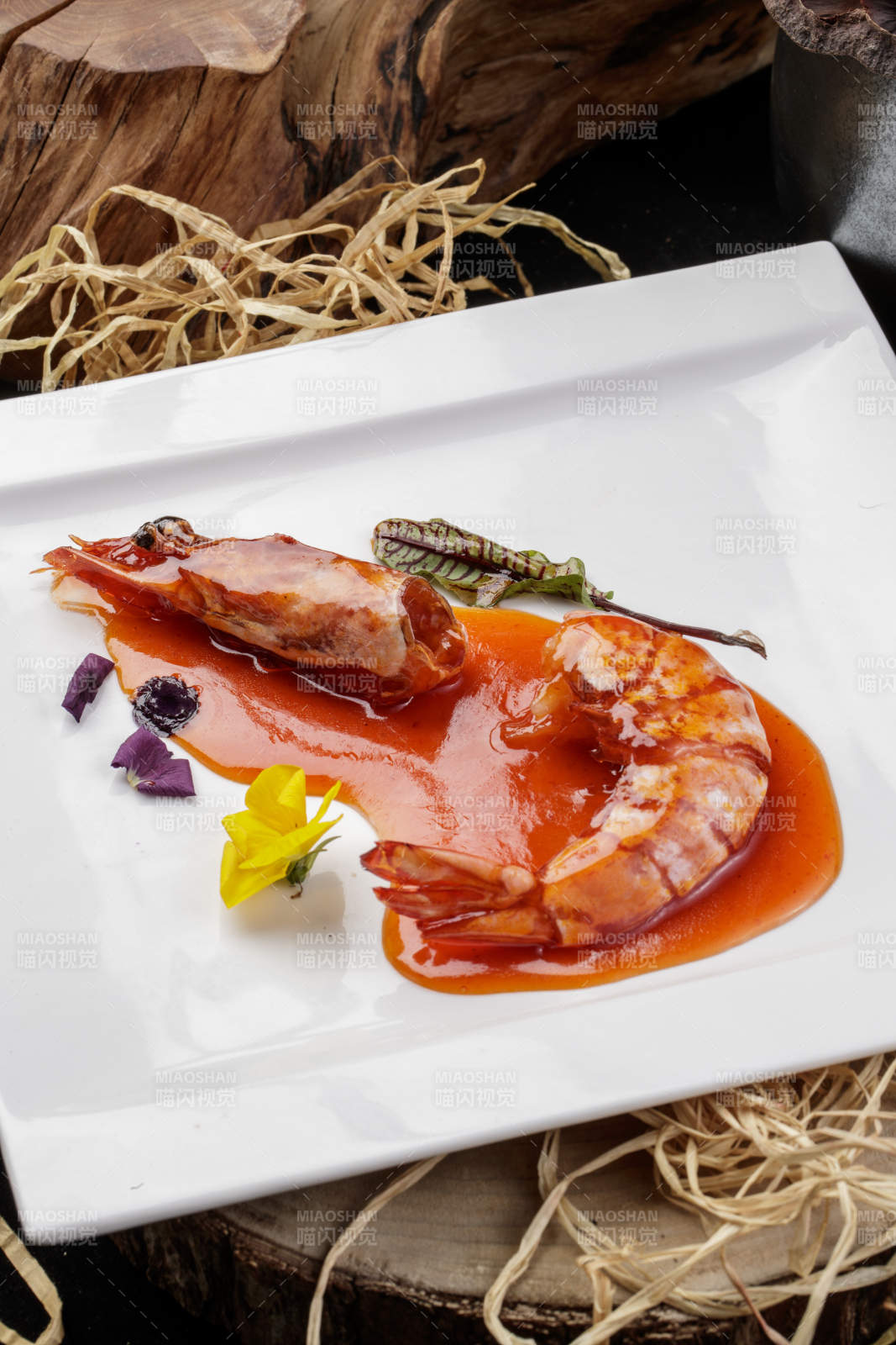 方形瓷盘装的浇汁大明虾摆放在樟木砧板上图片