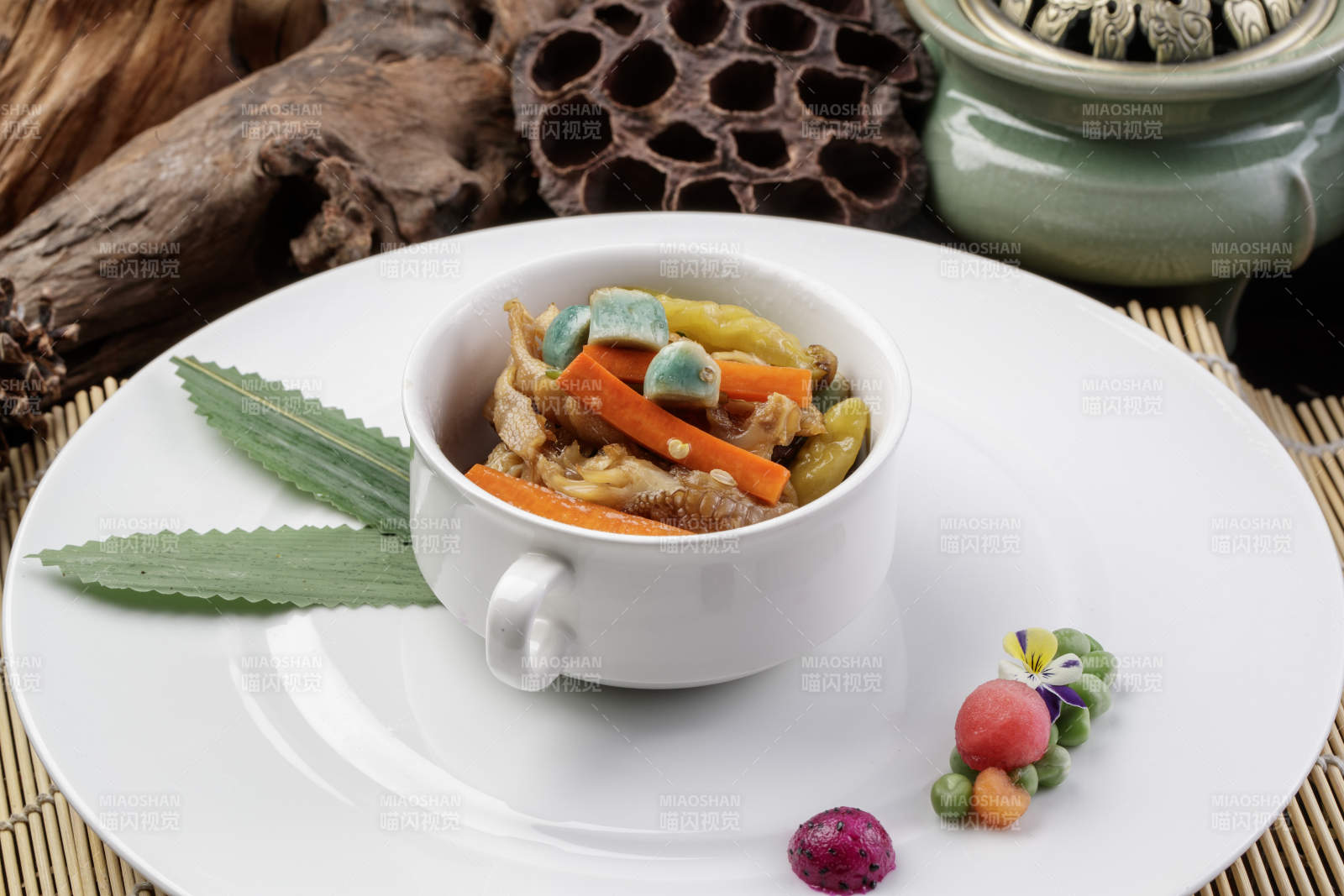 圆形瓷盘装的腊八蒜山椒凤爪摆放在寿司帘上图片