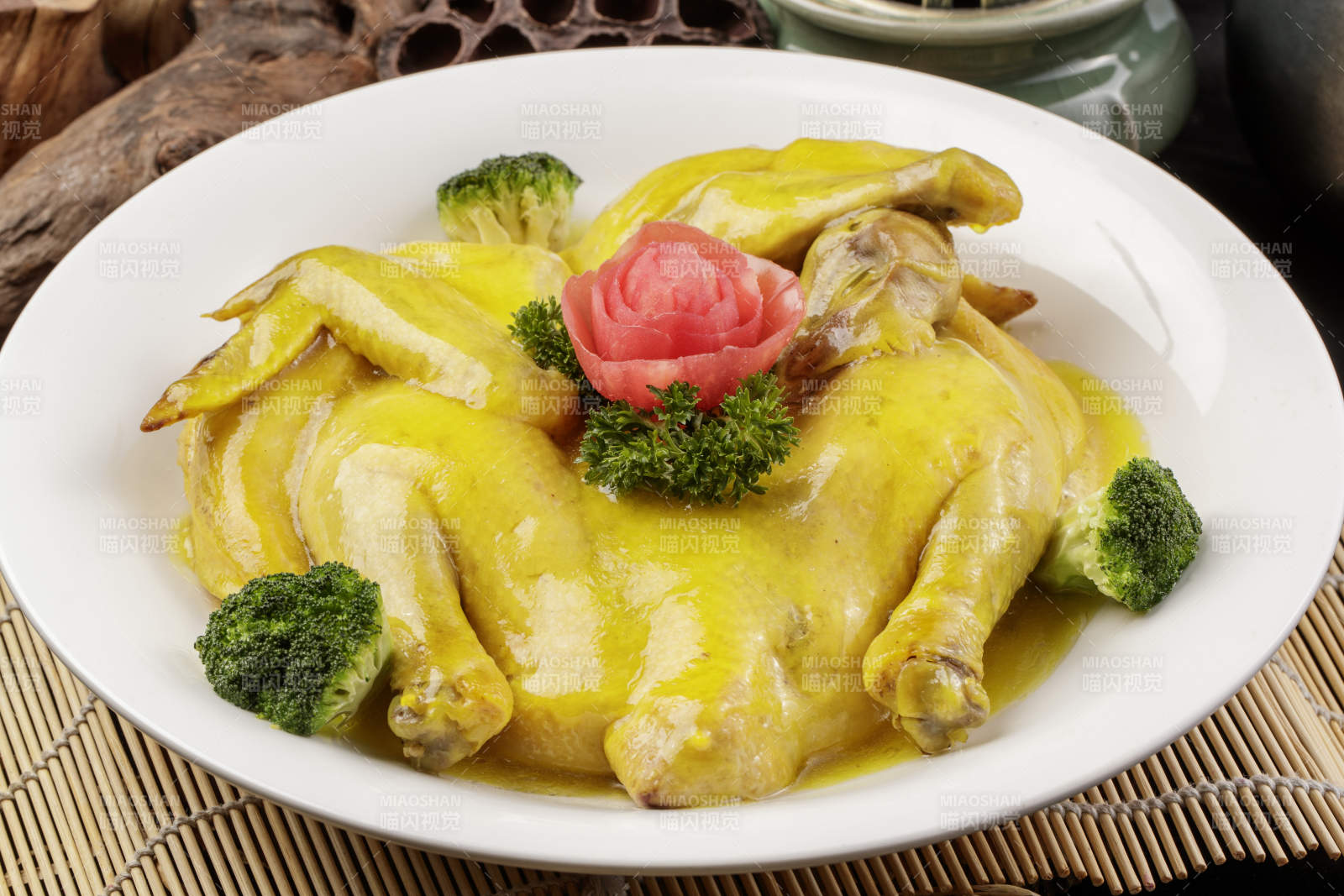 圆形瓷盘装的清蒸三黄鸡摆放在寿司帘上图片