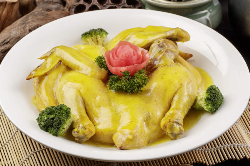 圆形瓷盘装的清蒸三黄鸡摆放在寿司帘上图片