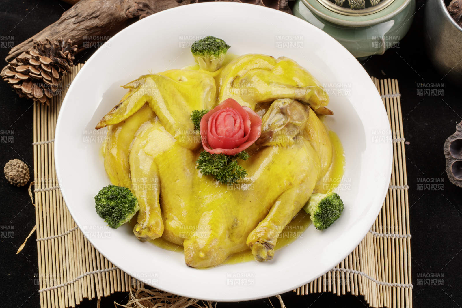 圆形瓷盘装的清蒸三黄鸡摆放在寿司帘上图片
